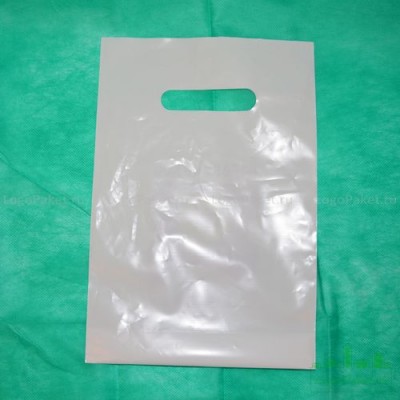 Пакет ПВД 50*40 см с вырубной ручкой и донной складкой лежит на зеленом фоне, показан с лицевой стороны.